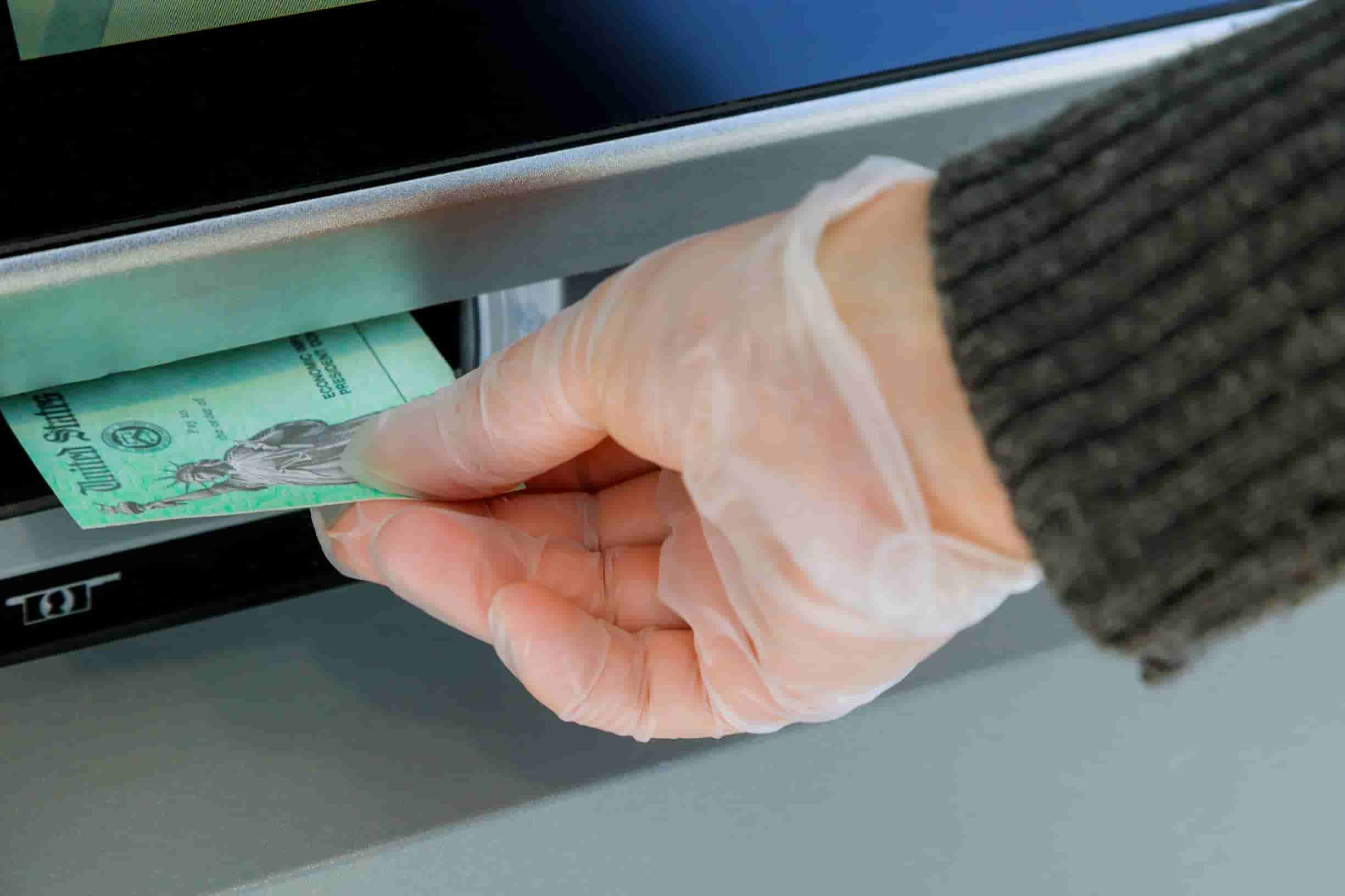 106870916 1618930432762 close up of hand entering deposit stimulus check to atm machine transfer t20 1n4d7Y
