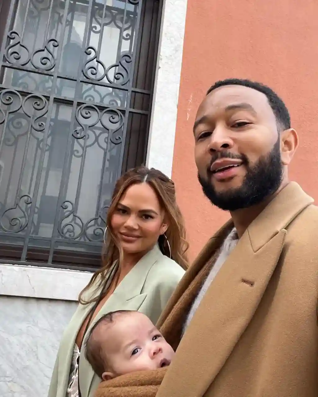 Teigen shared several snaps from her family’s trip to Venice, Italy, on Instagram Saturday, including one that showed Legend using a fuzzy swaddle to cradle their baby girl against his chest.